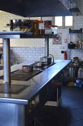 An empty commercial restaurant kitchen with stainless steel counters and equipment